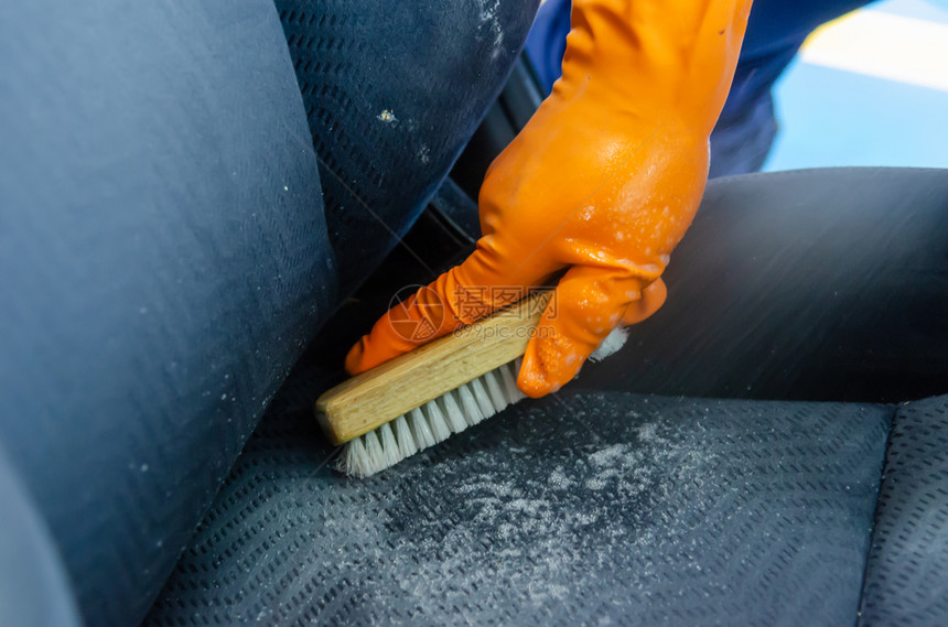 车库打扫男子佩戴手套以赶上汽车安全座椅清洁刷洗图片