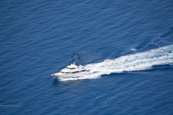 岛屿海洋水泡沫豪华游艇在西班牙巴利阿里群岛Mallorca的阳光明媚夏季日用海泡沫驶近岸图片
