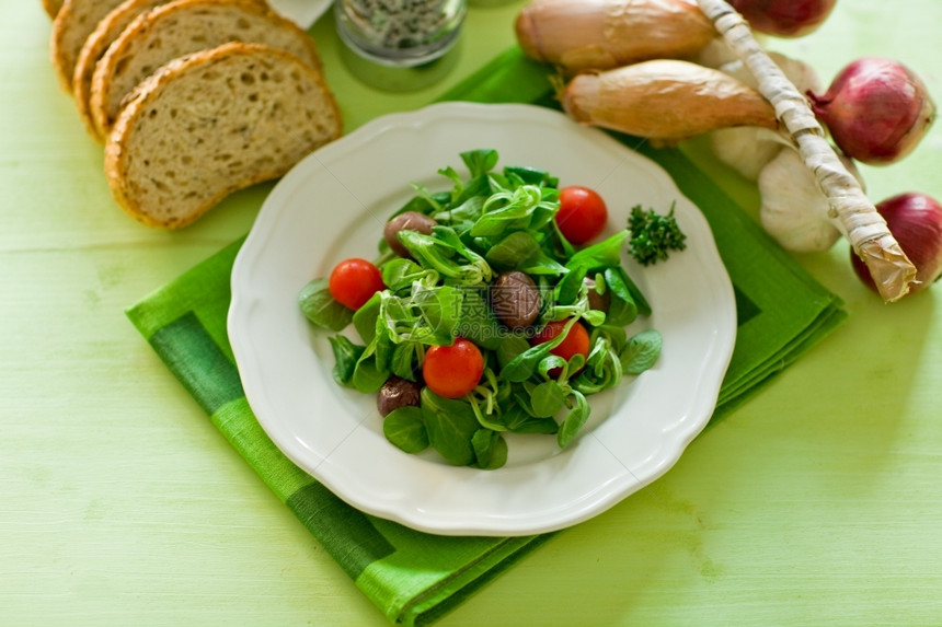 素食主义者木制的盐日光照亮绿木桌上美味素食沙拉图片