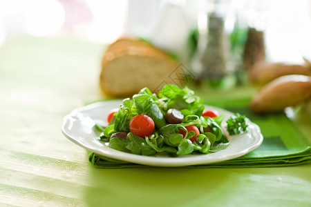 切片日光照亮的绿木桌上美味素食沙拉木制的绿色图片