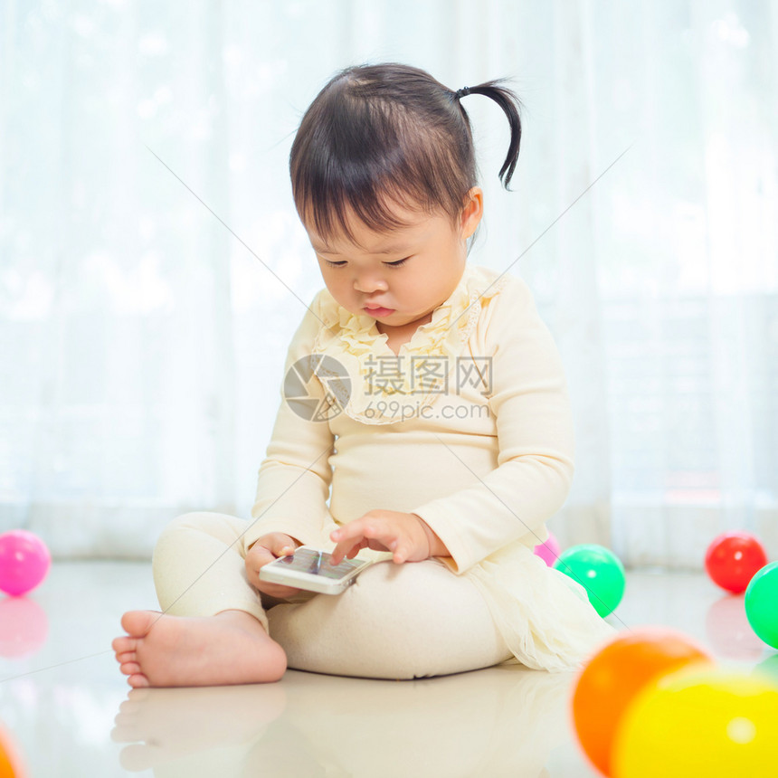 坐在地上玩耍的小女孩图片