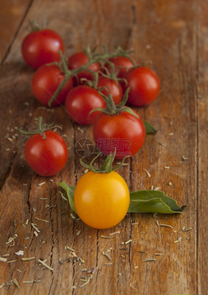 一种明亮的蔬菜樱桃西红柿在天然光照的木表面图片