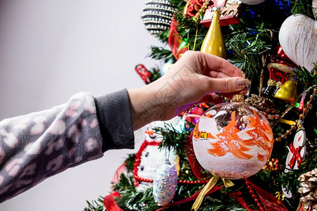 圣诞节将临将圣诞装饰品挂在圣诞树上背景
