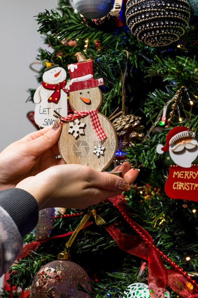 将雪人装饰品挂在圣诞树上图片