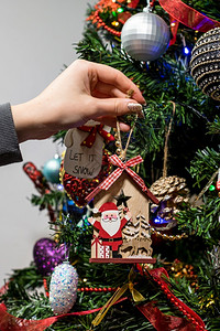将装饰品挂在圣诞树上图片