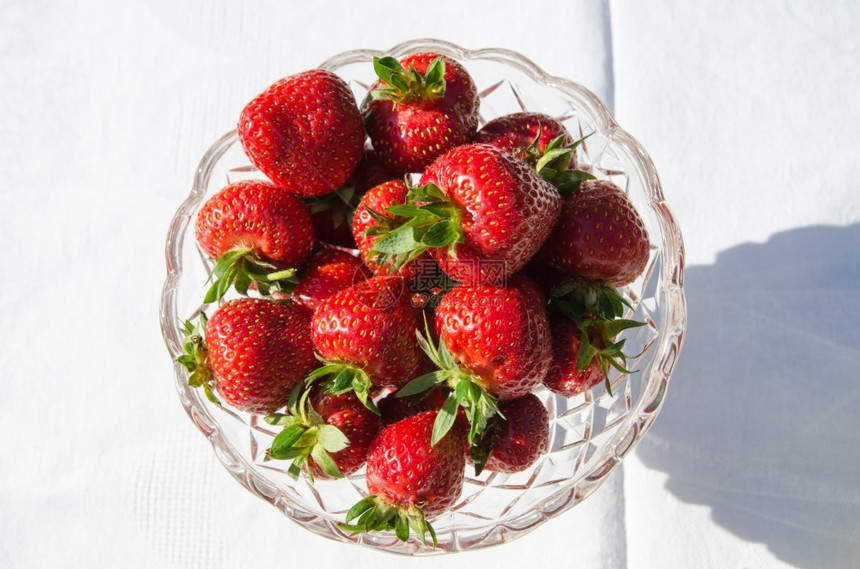 日光碗桌上有新鲜草莓和白布水果抗氧化剂阳光照射图片