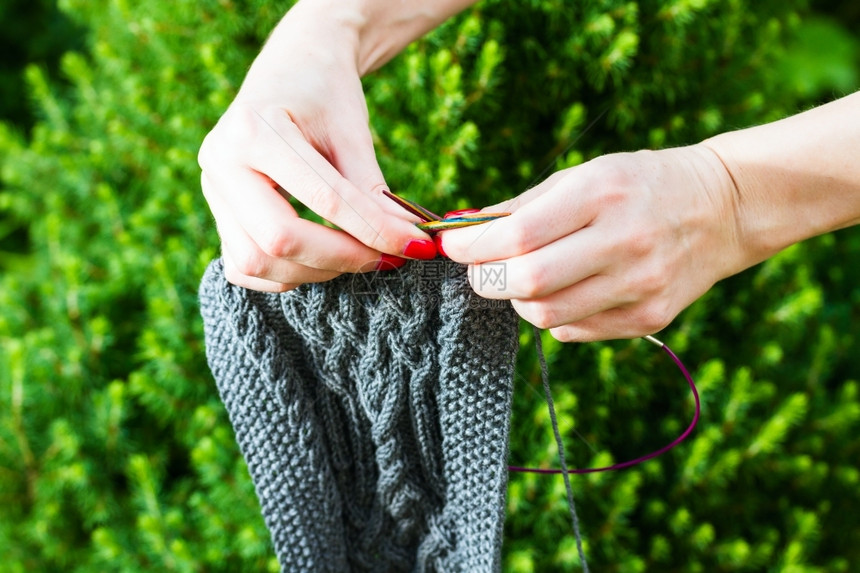 针织纺品手制羊毛围巾和女手持firtree背景编织波图片