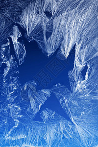 冷若冰霜白色的窗户上冰晶纹理和背景蓝色天空梯度上的冻结纹理窗玻璃上的季节背景Frost型样状冬季形态节背景磨砂冰冷设计图片