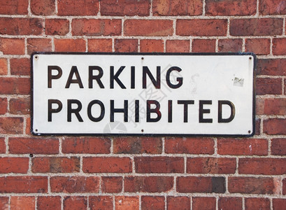 城市的违反红砖墙背景上的禁止停车旧牌号Name金属图片