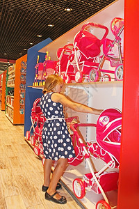 童年购买者女孩在玩具店里选择偶小女孩在具店里选择娃图片