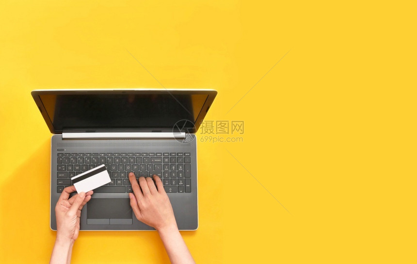 卡片店铺使用黄色背景信卡和笔记本电脑在网上购物的妇女买图片