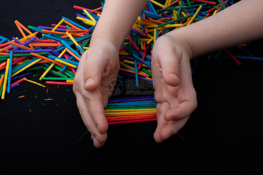 闲暇小孩用彩色木棍在白背景上发挥创造力玩彩色木棍为了孩子们图片
