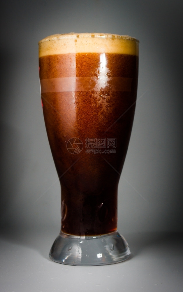 摄影啤酒杯装满冰冷的黑啤酒暗图片