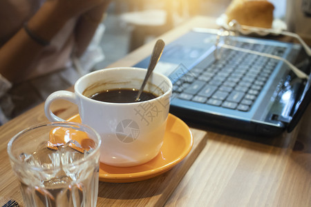 茶碗咖啡店木制桌上的咖啡和笔记本电脑划伤互联网图片