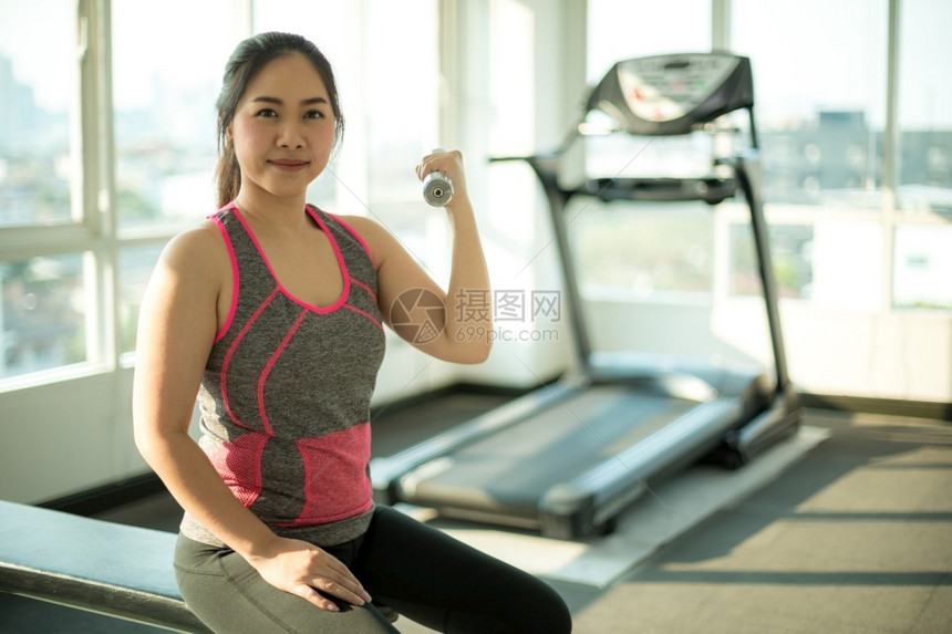 健身房拿着哑铃锻炼的女性图片