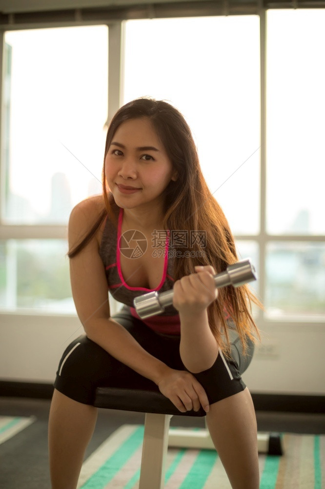 健身房拿着哑铃锻炼的女性图片