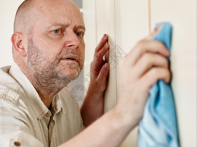 成熟50年代做家务打扫橱柜门的男子清洁图片