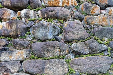 崎岖石方索洛维茨基修道院巨石墙壁的纹理草在裂缝中发芽不均匀的背景图片