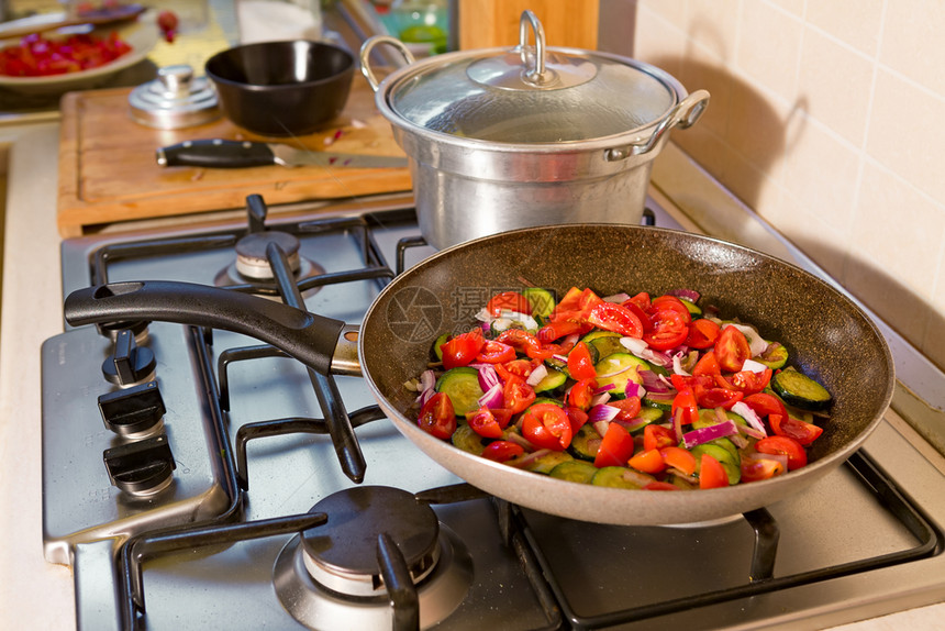 Zucchini樱桃西红柿和洋葱在锅炉上做饭整个遥远的意大利面加樱桃西红番茄和洋葱油颜色平底锅图片
