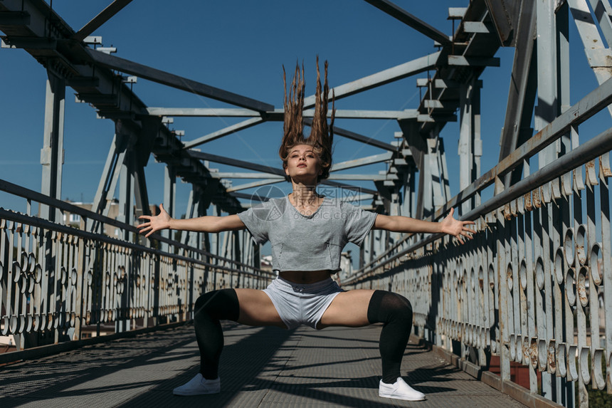 芭蕾舞蹈家长头发的年轻女孩在桥上装着女图片