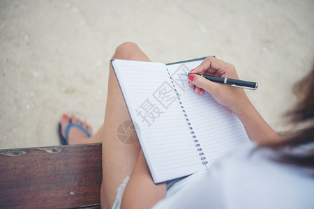 天坐着贴近女手写在笔记本上组织者图片