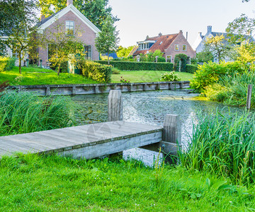 建造一种自然在池塘的木制码头对村舍进行观察图片