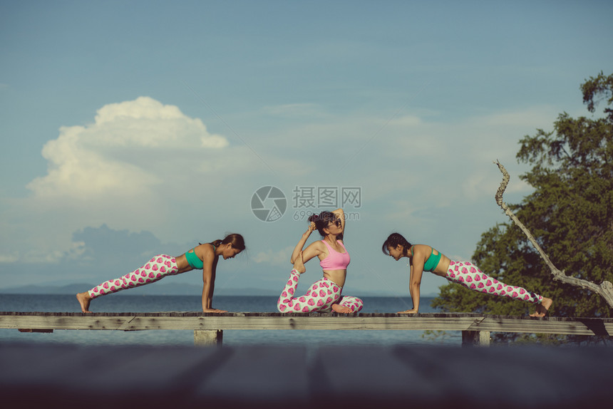 三个亚洲女人在海滩码头做瑜伽岛放松户外图片