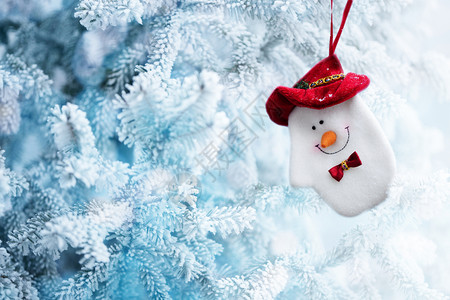 圣诞雪人索克在冰冻冬季森林的树枝上挂着背景复制空间霜冷杉红色的图片