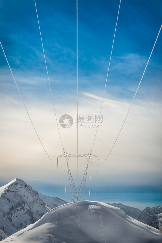 高山上雪积覆盖的赛塔将能量带往下游现代的电缆气图片