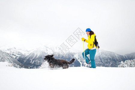 与雪鞋一起游时积多的是一个女孩和她心爱的狗背包雪鞋行走景观图片