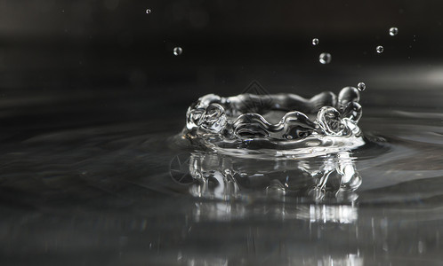 透明气泡喝水滴下宏观拍到的深色底图片