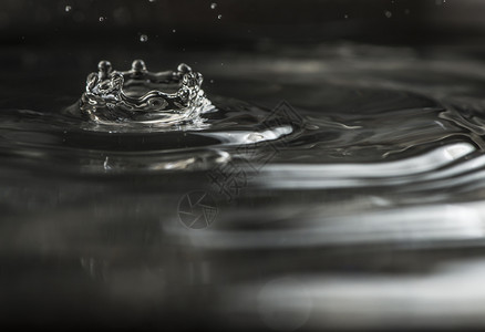 水滴下宏观拍到的深色底波纹洗王冠背景图片