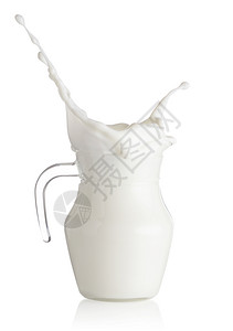 滗水器滴喷洒在玻璃脱盐牛奶中隔绝在白色背景上喷洒在玻璃脱漆牛奶中白色的饮料设计图片