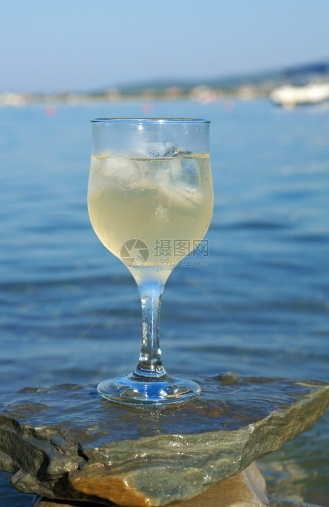 水海浪冲刷的岩石边杯白葡萄酒被海浪冲洗过波请享用图片