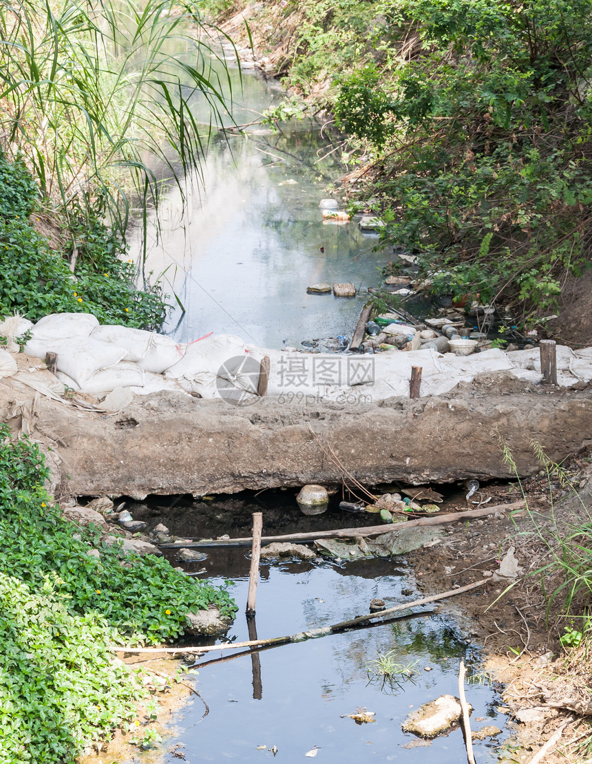 污水工业的区用小沙袋大坝建造的废水运河溪流图片