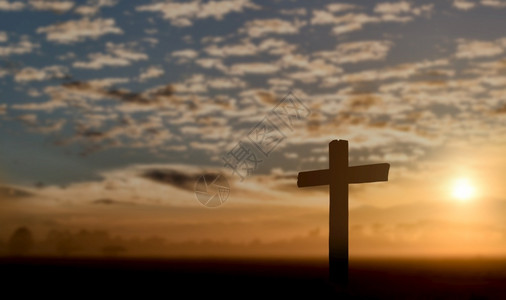 轮廓钉日落背景的天主教十字月光环图片