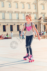 骑城市开支年轻女孩在一个小镇滑溜冰在夏天的白户外积极度过时间图片