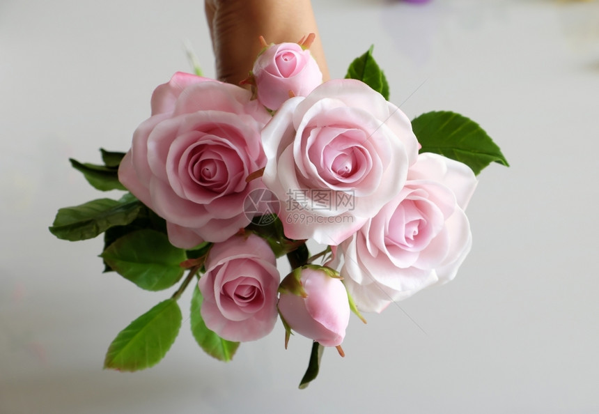 粉色的大叻美妙粘土艺术女人手握花束朵粉红在白色背景上美丽的人造花朵精巧的手工艺团体图片
