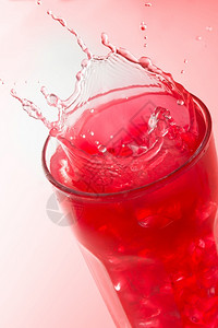 满杯百香果有角度的红色背景草莓果汁杯上紧贴着喷洒冰溅起设计图片