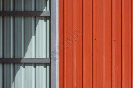 结构体灰色的或者储藏室车库钢墙表面的阳光和阴影室内外有橙金属板壁围墙的储藏室或车库建筑材料概念背景图片