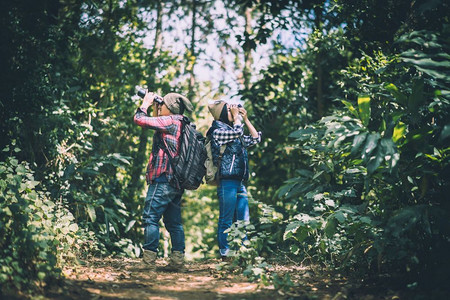 年轻夫妇在森林冒险远足时带着背包散步一起享受节假日自然徒步旅行者图片
