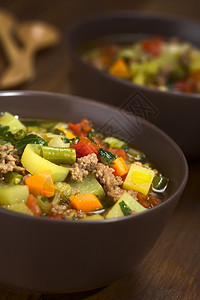 食物碎肉盘子菜汤有薄荷绿豆土利叶胡萝卜番茄和鹦鹉等蔬菜汤用于棕碗图片