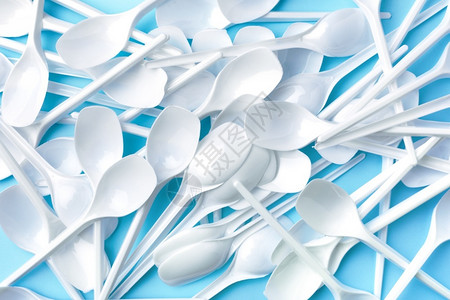 一勺子白糯米保护可回收蓝色背景的白塑料勺子生态问题的概念生态问题社会的设计图片