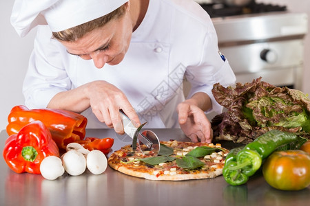 厨房刀具大量的煮饭切地中海披萨加蔬菜和奶酪图片