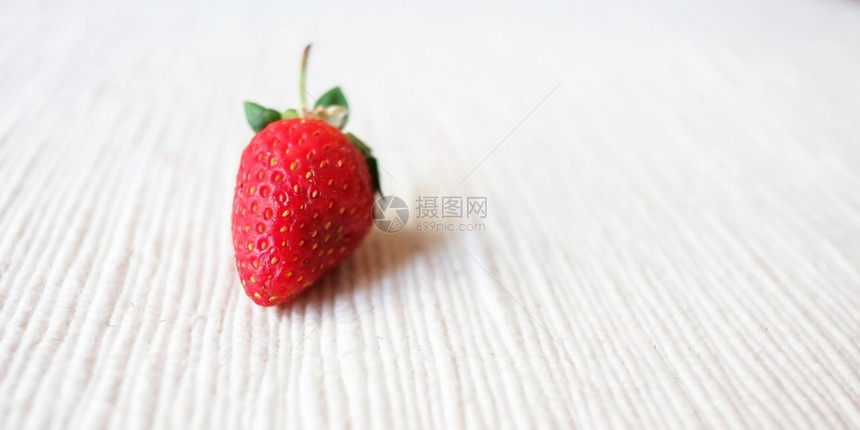 成熟桌子白布上的草莓浆果图片