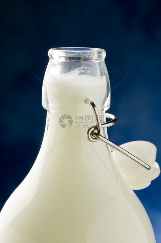 正面蓝色背景前的牛奶瓶照片一种新鲜图片