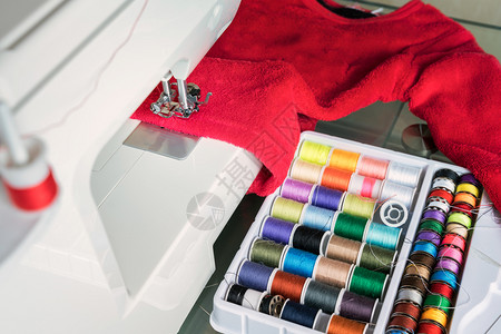 制造裙子过度缝合纫机和红布超铺层阶段的缝纫过程彩色水池图片