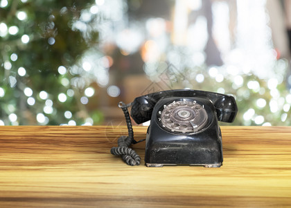 木棕色桌上黑旧电话背景为夜间bokeh沟通拨号黑色的背景图片
