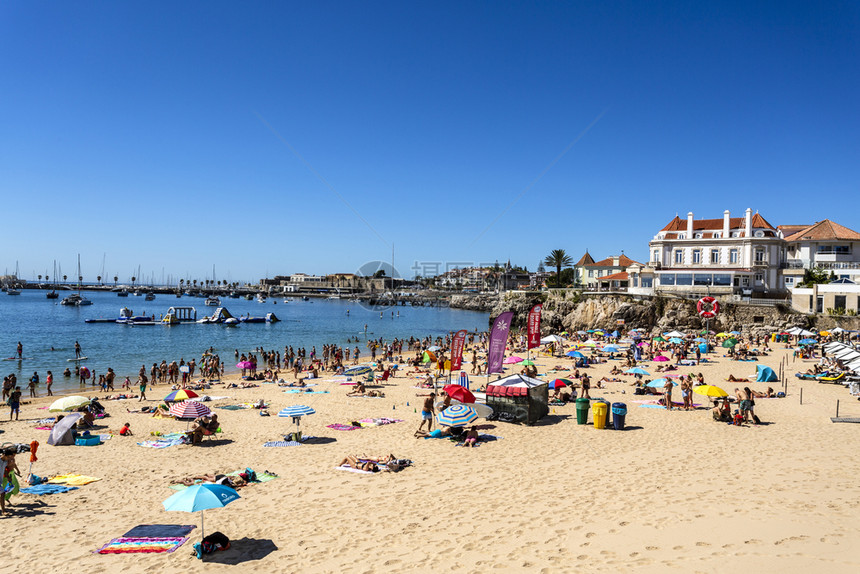 在葡萄牙里斯本附近的埃托里尔和卡凯两镇之间的海滩列车旁可以看到一个叫普拉亚达孔塞卡奥的拥挤小海滩外部洗澡埃斯托利尔图片