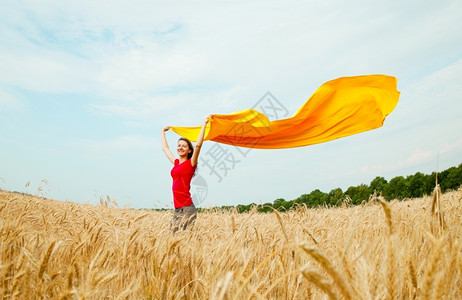 自然乡村的在阳光明媚日子里在麦田小有黄织物的少女户外图片